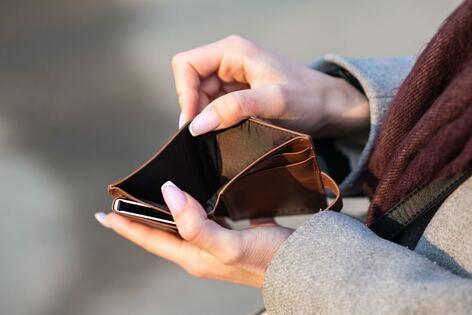 Person looking in empty wallet as image for blog post section on how to afford a doula